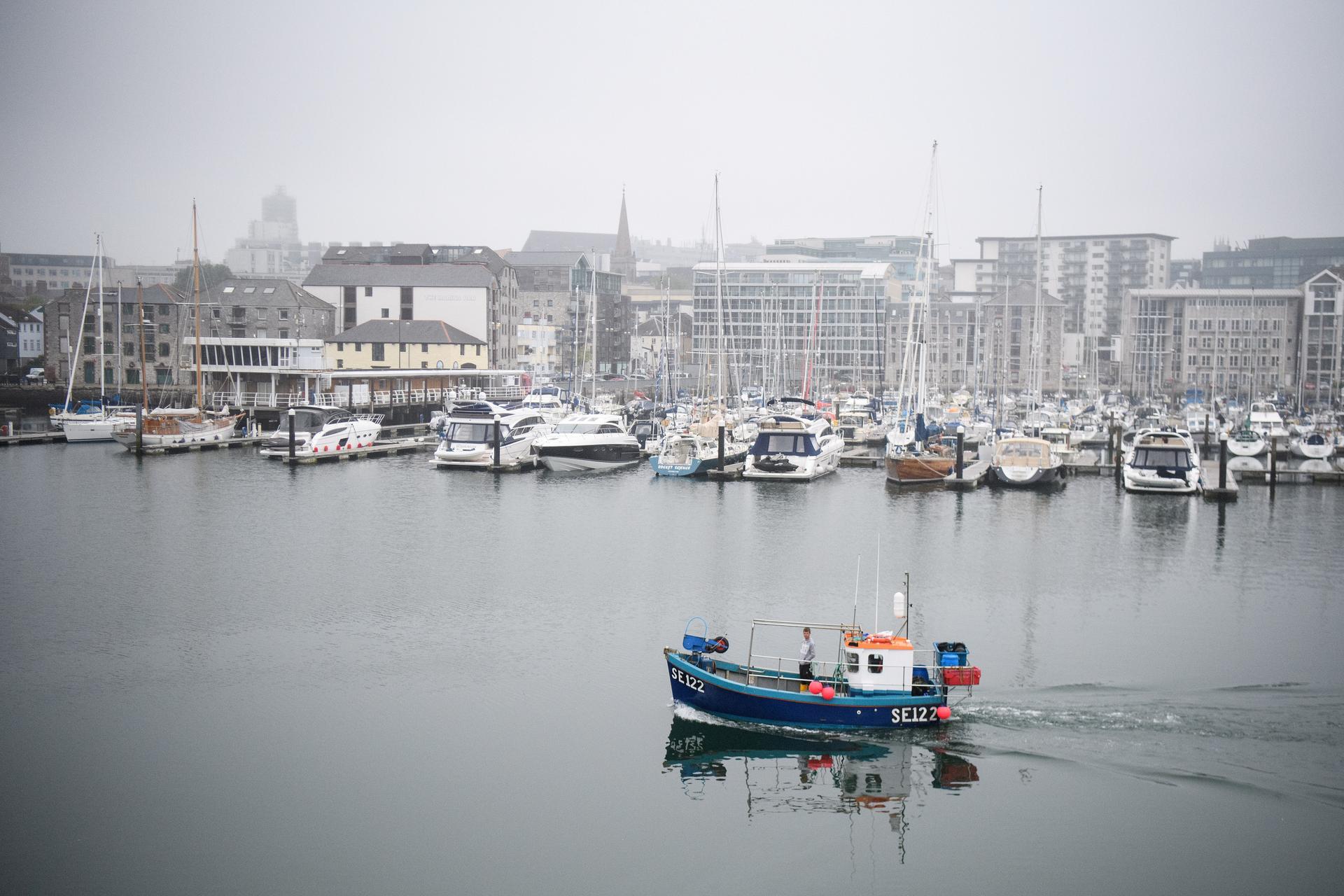 A fishing boat sails from the harbor in Plymouth