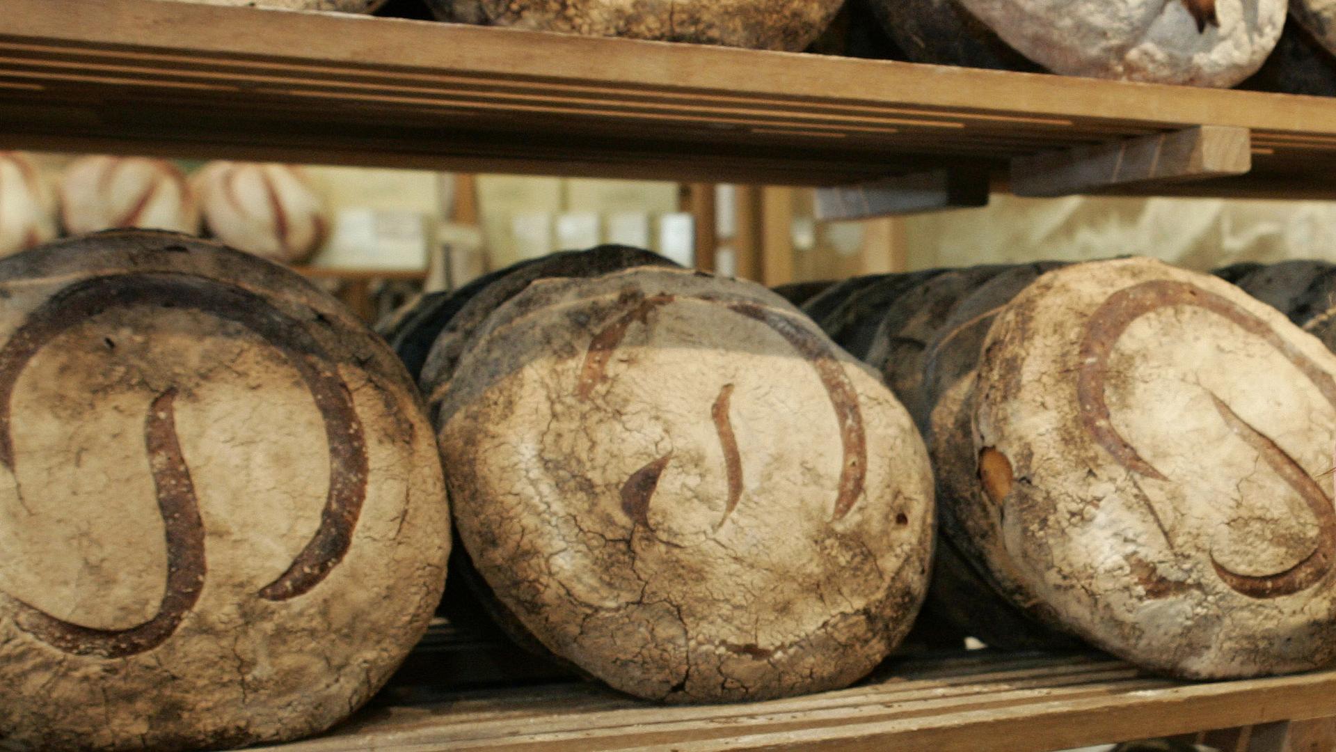 Freshly baked Miche line the walls at the original Poilane family bread bakery in Paris.