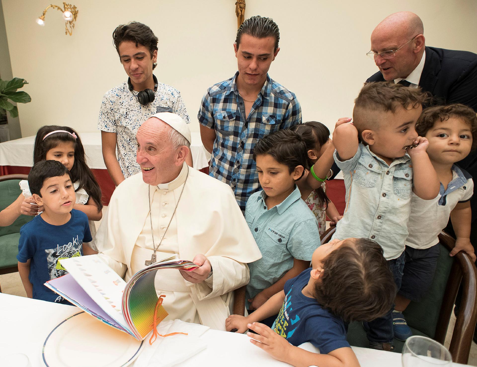 Pope Francis sits with some Syrian refugees