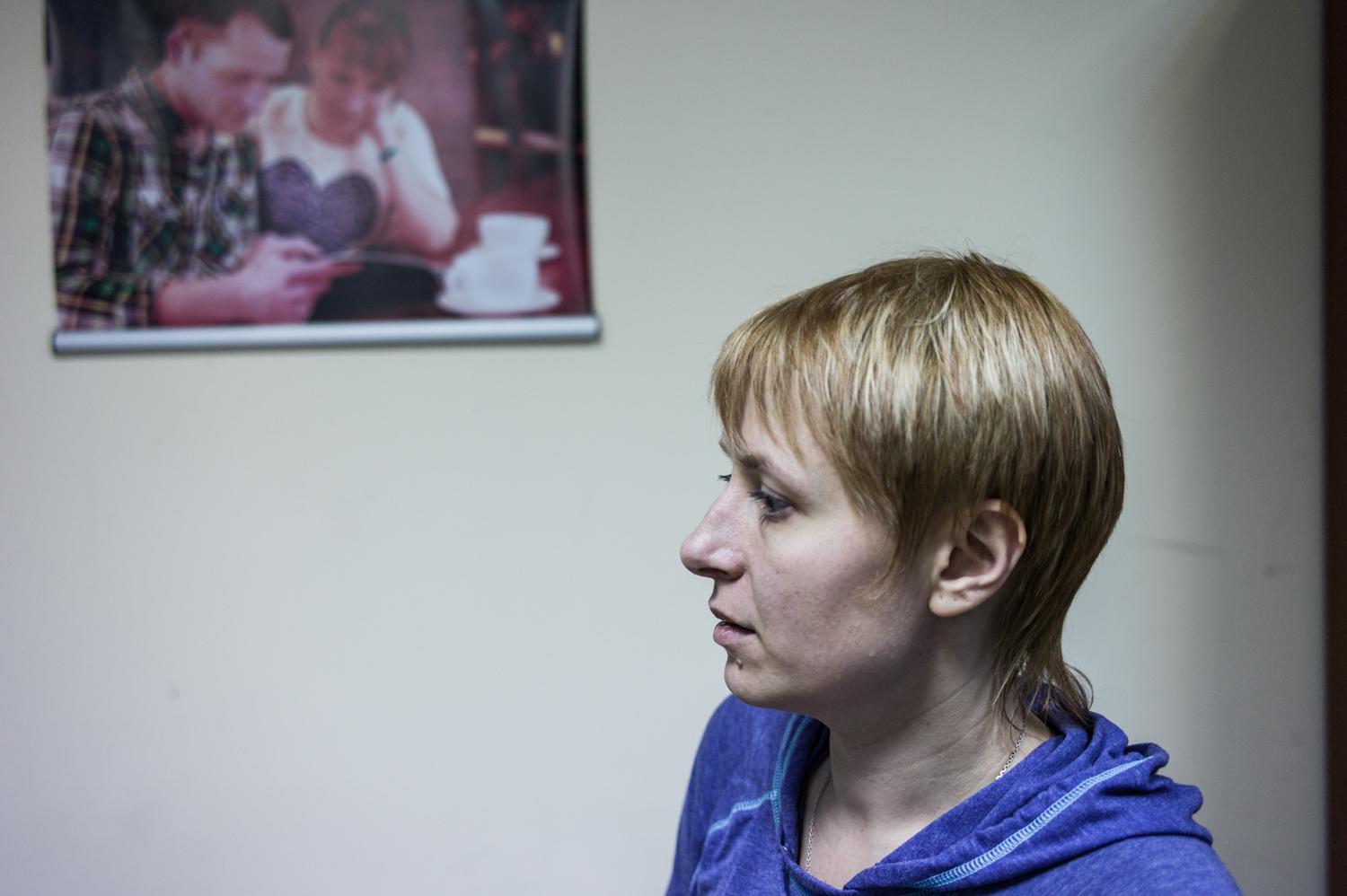 Waiting for news about her husband's fate, Svitlana Moroz stands in a Kiev NGO in front of a photograph showing her with her husband Aleksei in peaceful time.