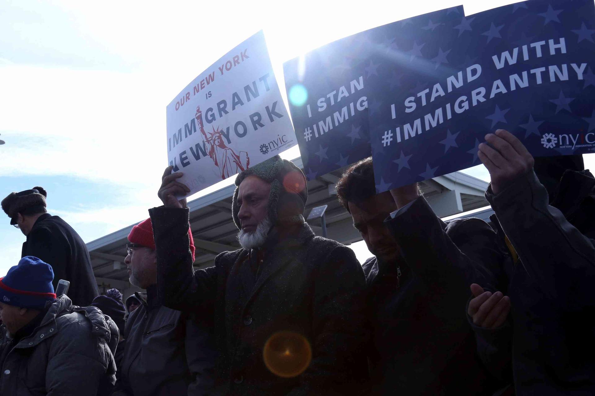 People hold signs during an interfaith action and Jummah prayer outside Terminal 4 at John F. Kennedy Airport in New York, U.S., February 3, 2017.