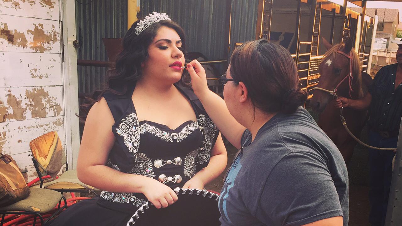 Jaqueline Valencia touches up her sister Kimberly's make-up during Kimberly's ranch-themed photo shoot.