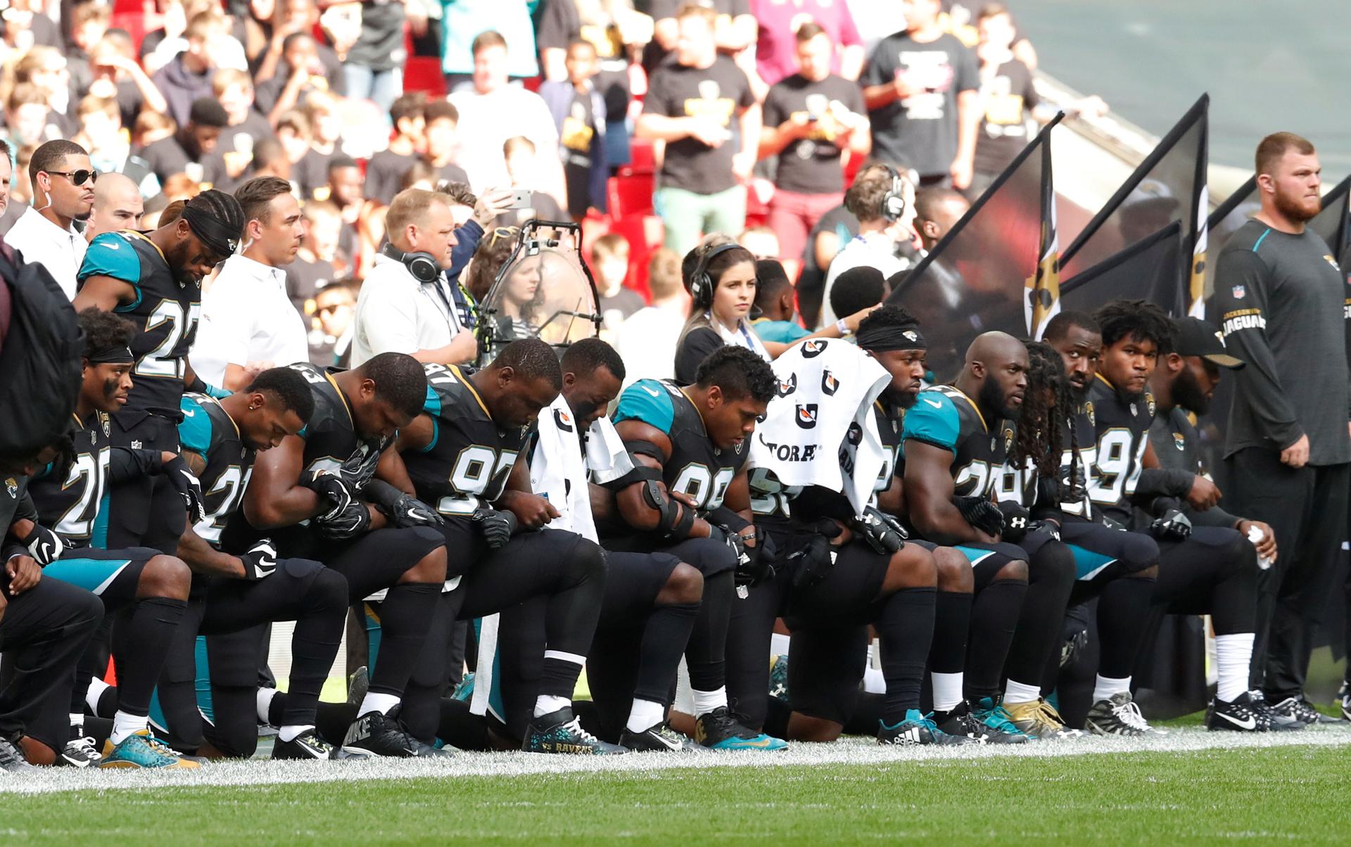 Jacksonville Jaguars players kneel during the US national anthem before their game against the Baltimore Ravens.