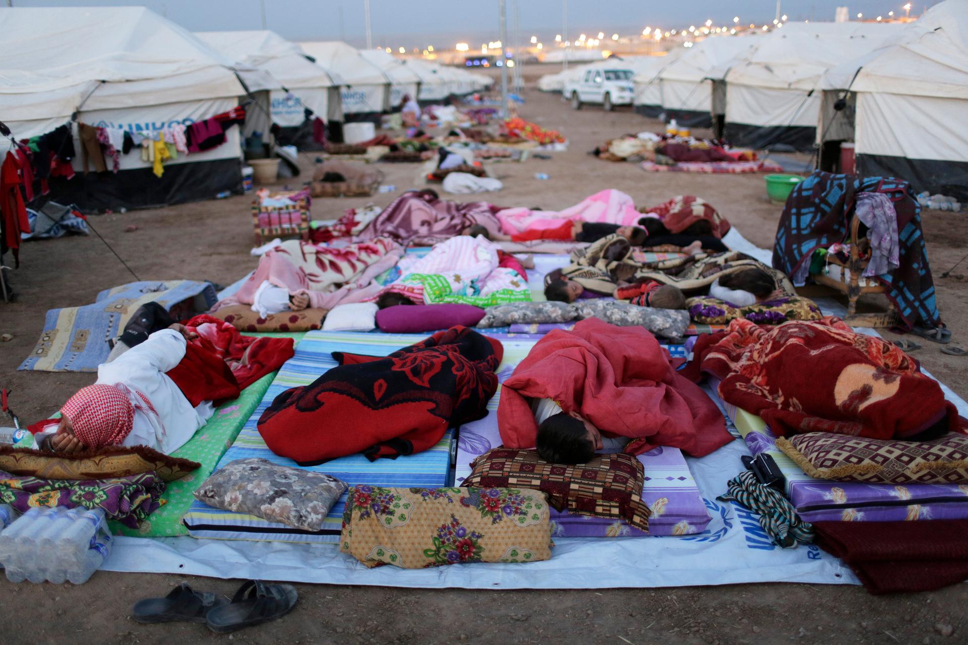 Displaced people from the minority Yazidi sect, who fled violence in the Iraqi town of Sinjar, sleep on the ground at the Bajed Kadal refugee camp in southwest Dohuk province on August 23, 2014.
