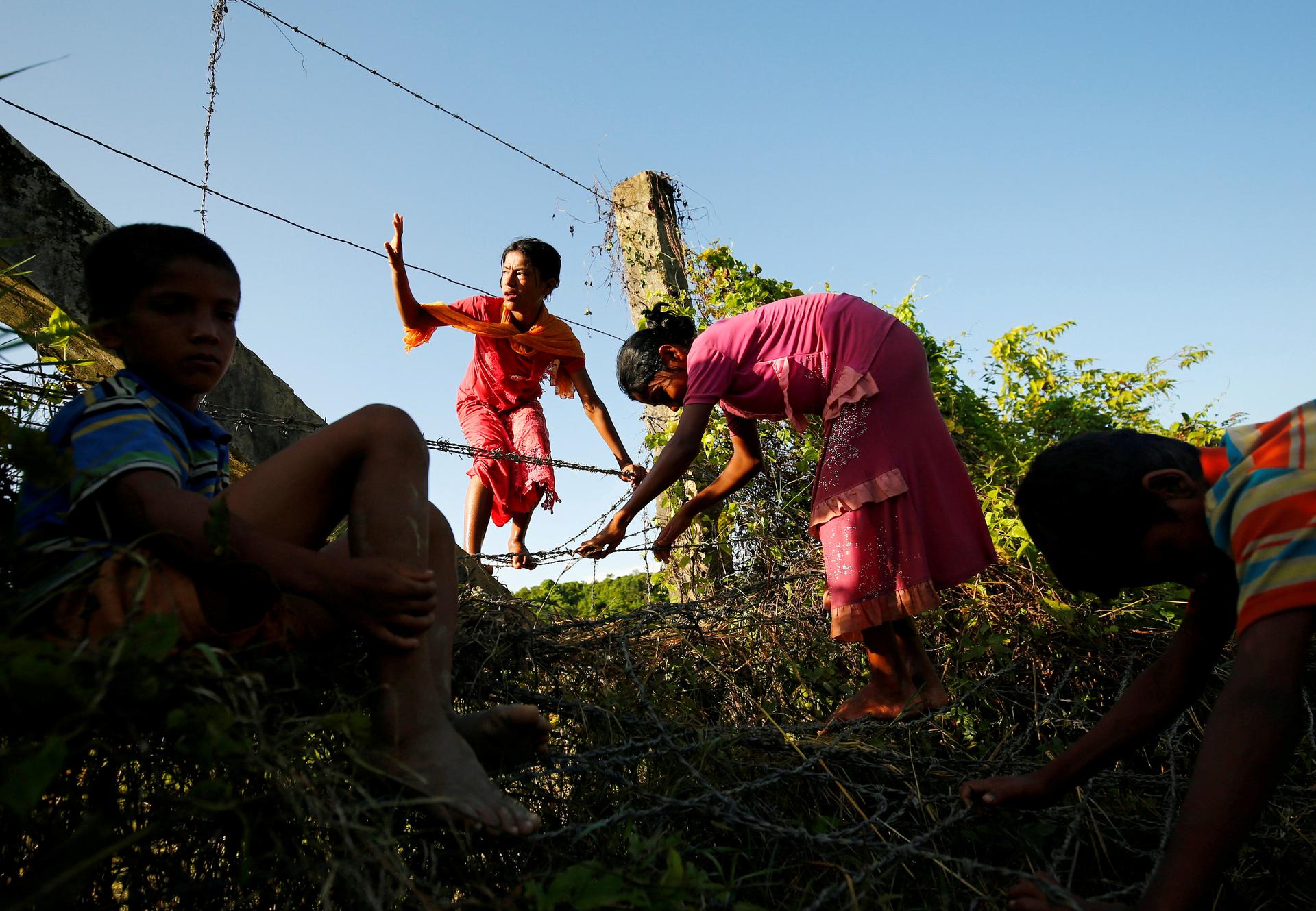 Rohingya children cross the Bangladesh-Myanmar border fence