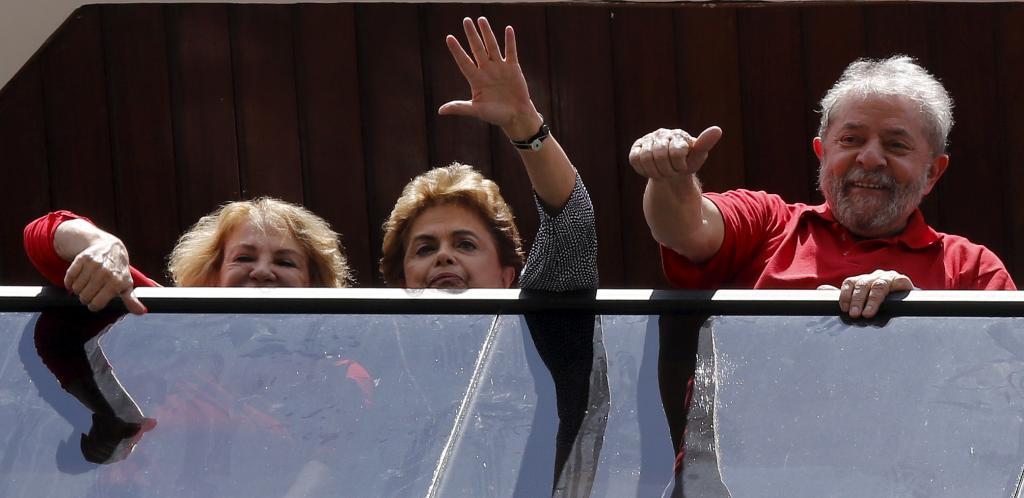 Former Brazilian President Luiz Inacio Lula da Silva, right, his wife, left, and incumbent Dilma Rousseff wave from the window of his home in Sao Bernardo do Campo, Brazil, March 5.
