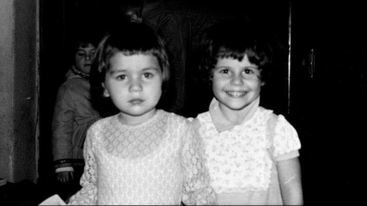 Rukmini, 5 years old and scowling next to her best friend Ilinca before fleeing Romania circa 1979 or 1978.