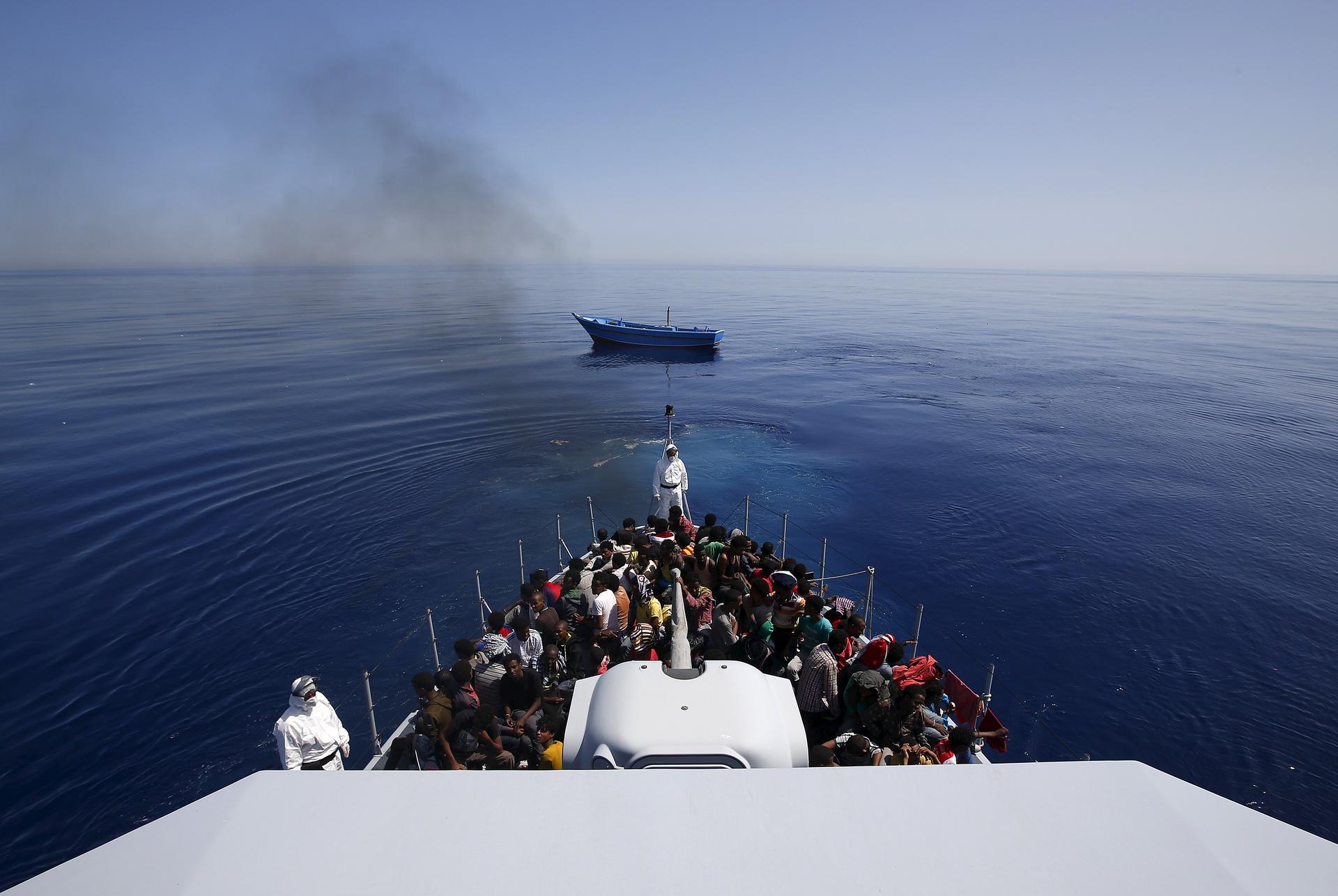 A group of 300 sub-Saharan Africans sit on board an Italian police vessel as their boat is left adrift off the coast of Sicily, May 14, 2015.