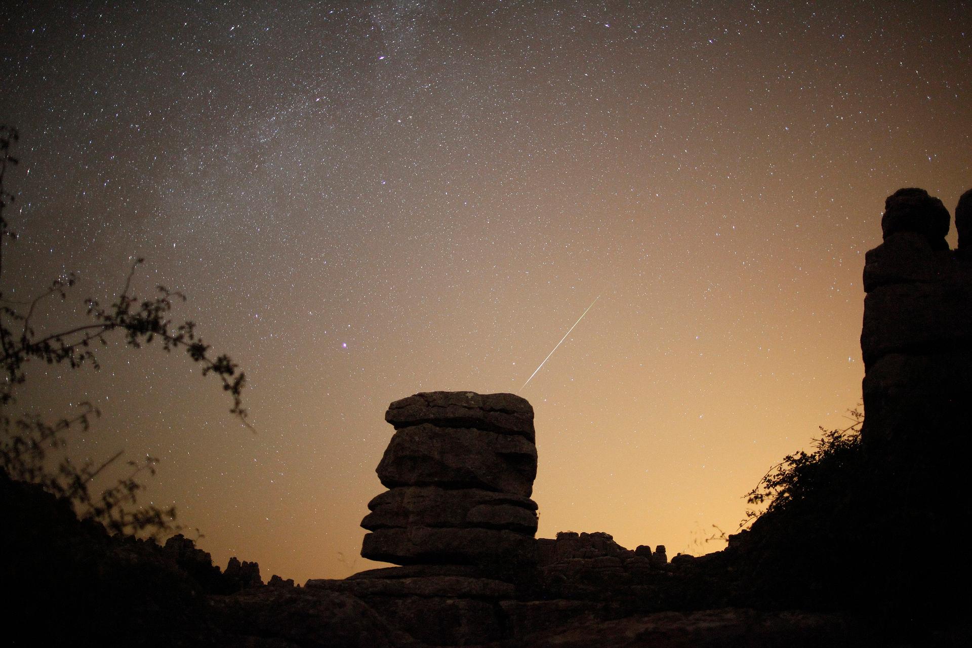 A meteor streaks past stars in the night sky over El Torcal nature park
