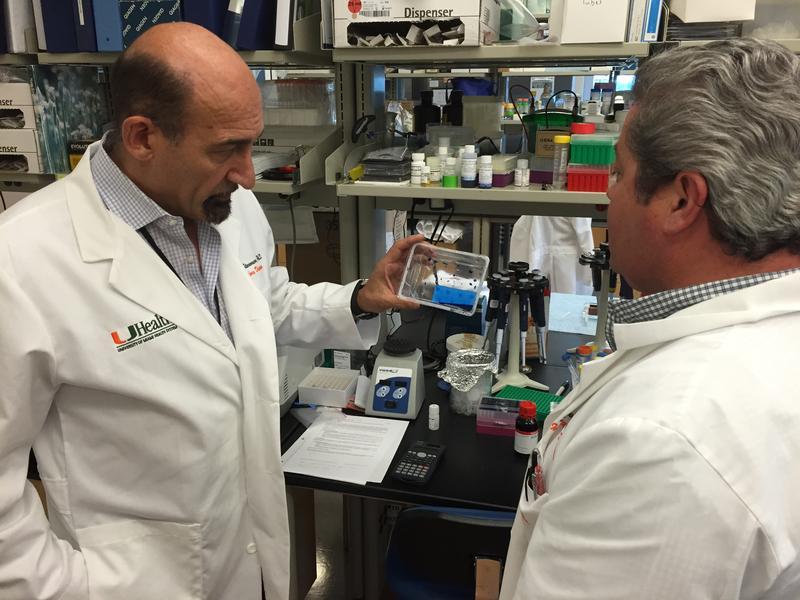 UM's Mario Stevenson (left) examines a new Zika virus detection test at his team's Miami lab.