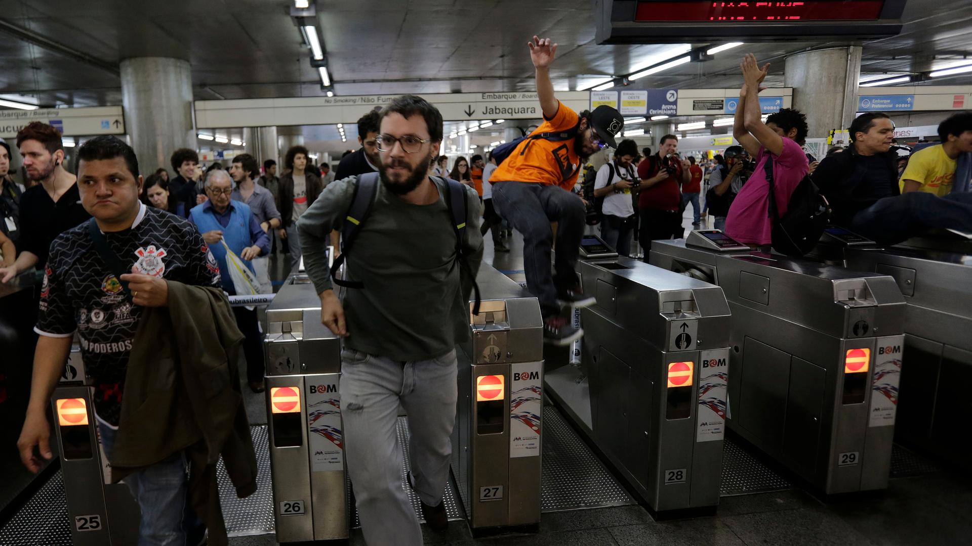 Demonstrators jump over the turnstiles without paying subway fare in support of a strike by metro workers in Sao Paulo June 9, 2014. Brazilian police used tear gas on Monday to disperse metro workers on strike in Sao Paulo in defiance of a court order to