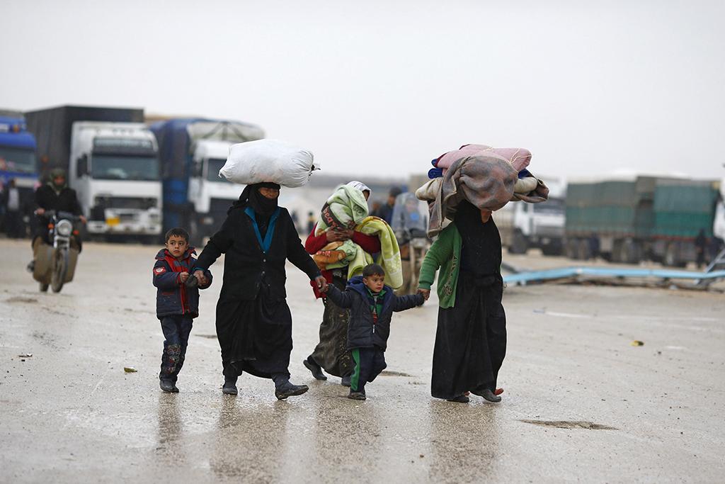 Internally displaced Syrians carry their belongings as they arrive at a refugee camp near the Bab al-Salam crossing, across from Turkey's Kilis province, on the outskirts of the northern border town of Azaz, Syria, Feb. 6, 2016.