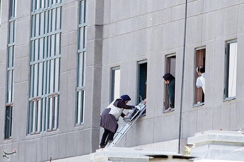 A woman is evacuated during an attack on the Iranian parliament in central Tehran, Iran.