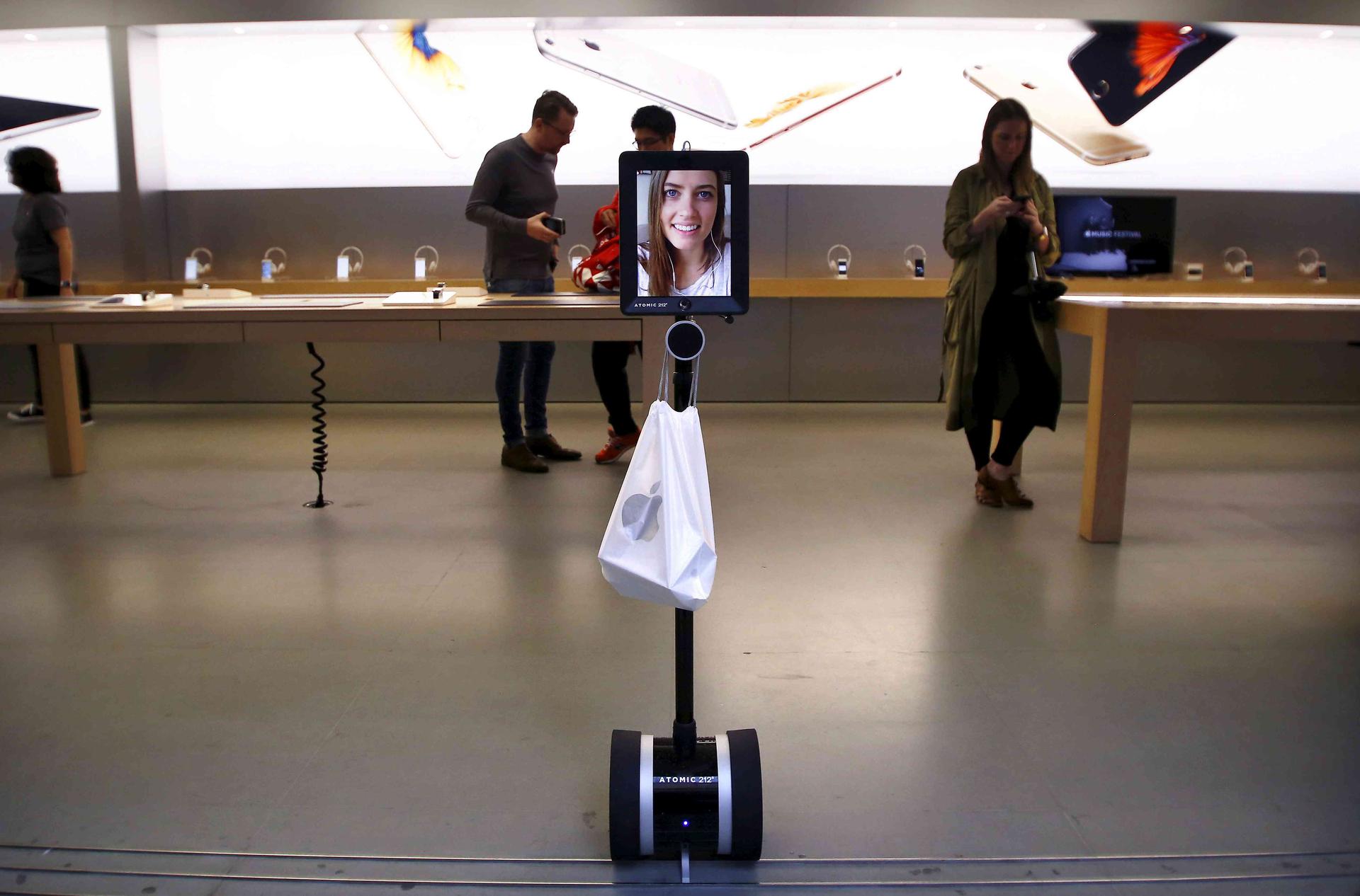 Lucy Kelly is seen on a screen attached to a telepresence robot
