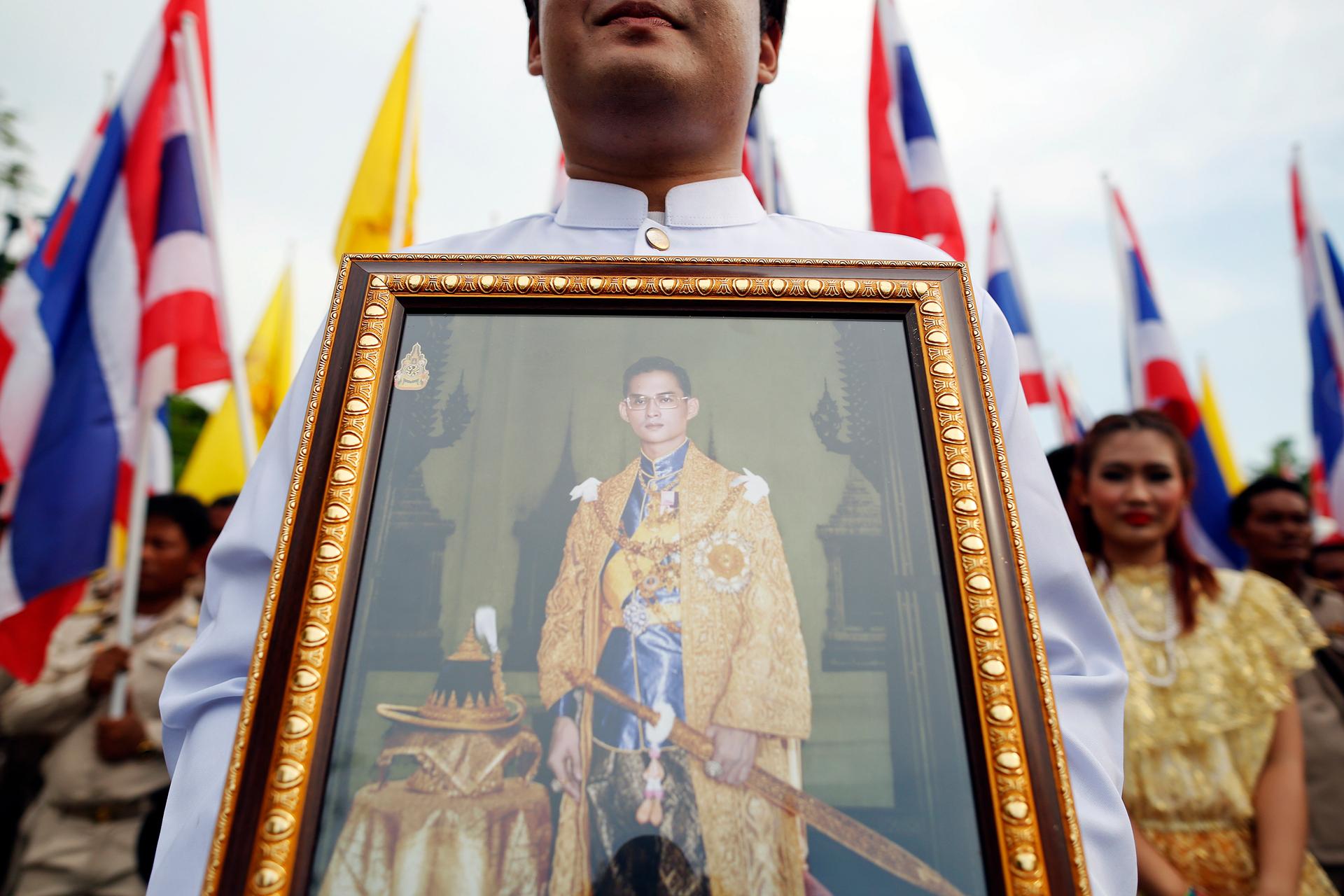 A well-wisher holds a picture of Thailand's King Bhumibol Adulyadej as he joins anti-government protesters gathering outside the Grand Palace on Coronation Day in Bangkok May 5, 2014.