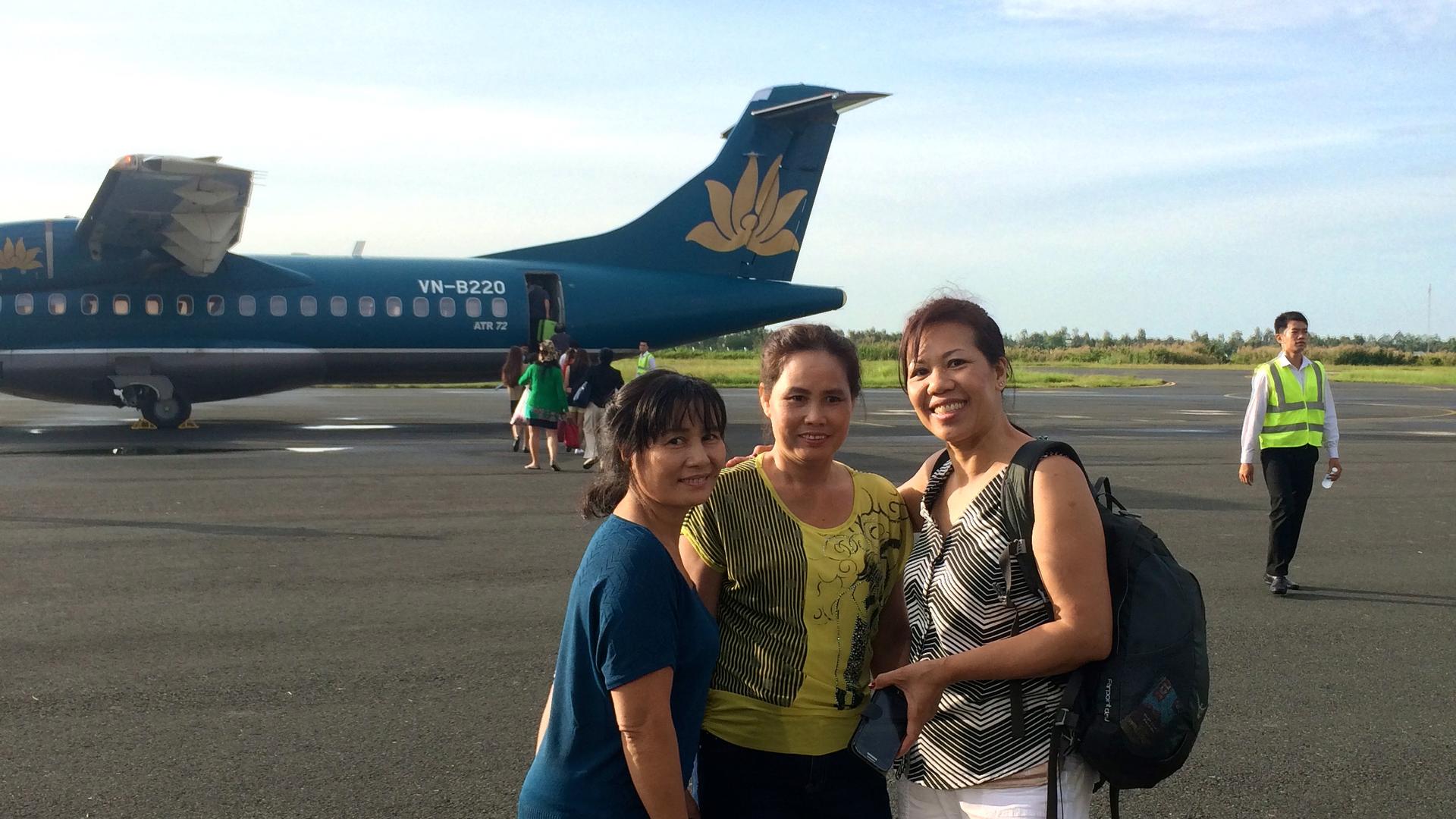 Mai, Tot and Ngoc Bich Ha, Cecilia Tran's mother, stand in front of an Vietnamese airplane.