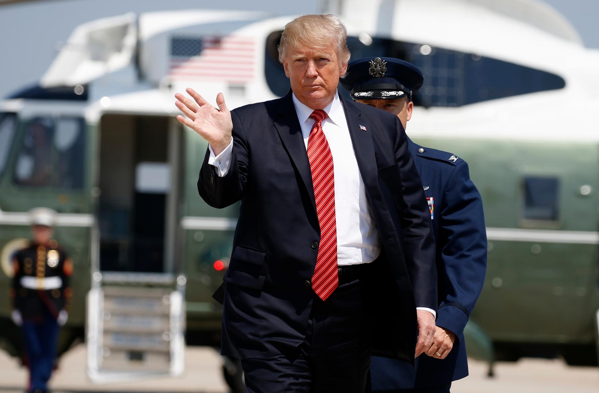 President Donald Trump waves before departing for Arizona