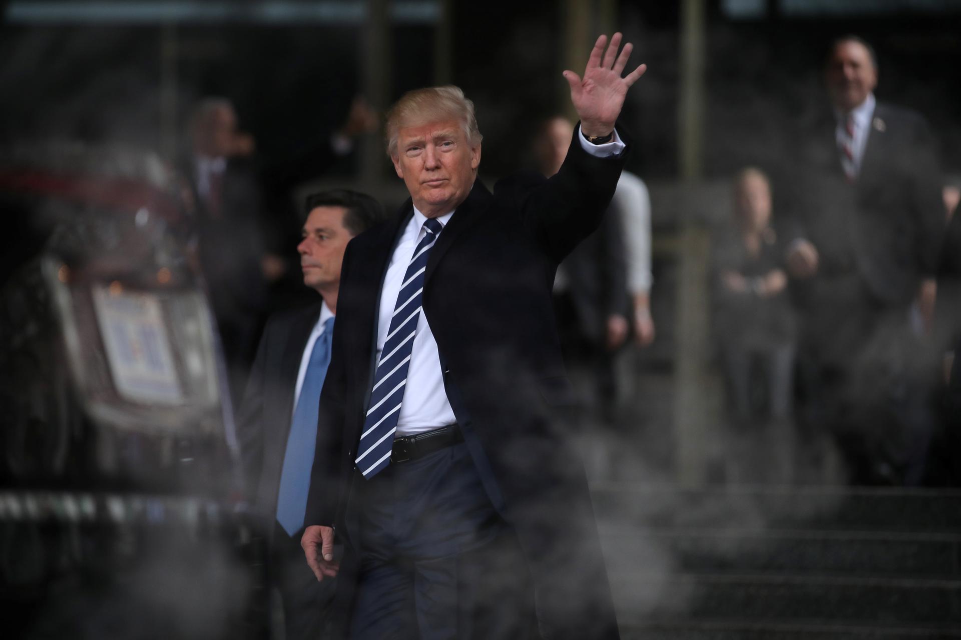 US President Donald Trump waves as he leaves the CIA headquarters