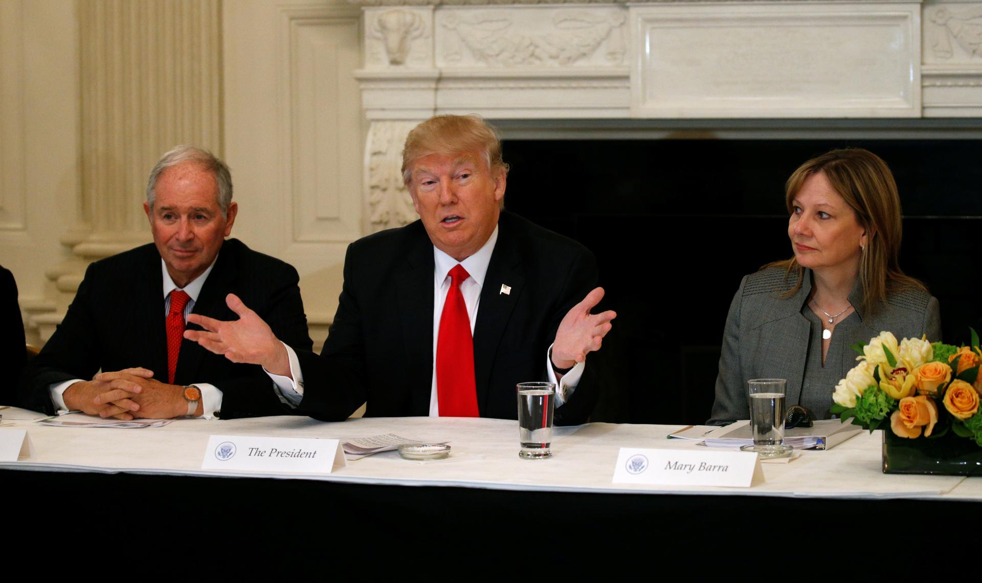 Flanked by Blackstone CEO Stephen Schwarzman, left, and General Motors CEO Mary Barra, US President Donald Trump holds a strategy and policy forum