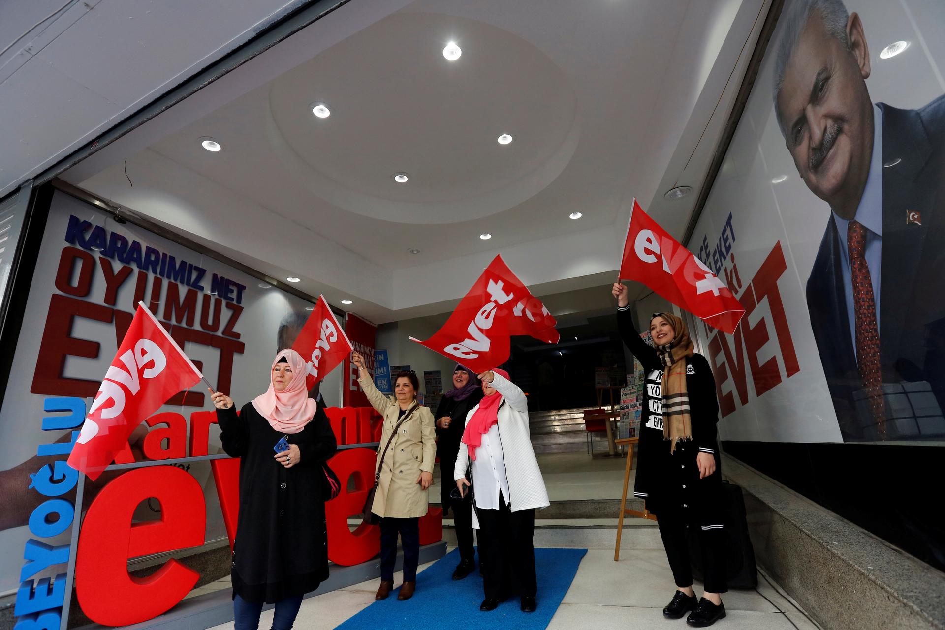 Women wave "Yes" flags at a campaign office of the ruling AK Party
