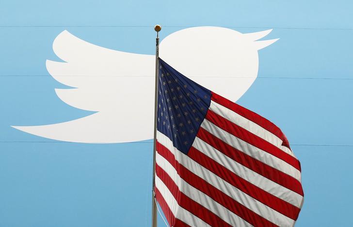 The white bird Twitter logo appears behind the American flag. 