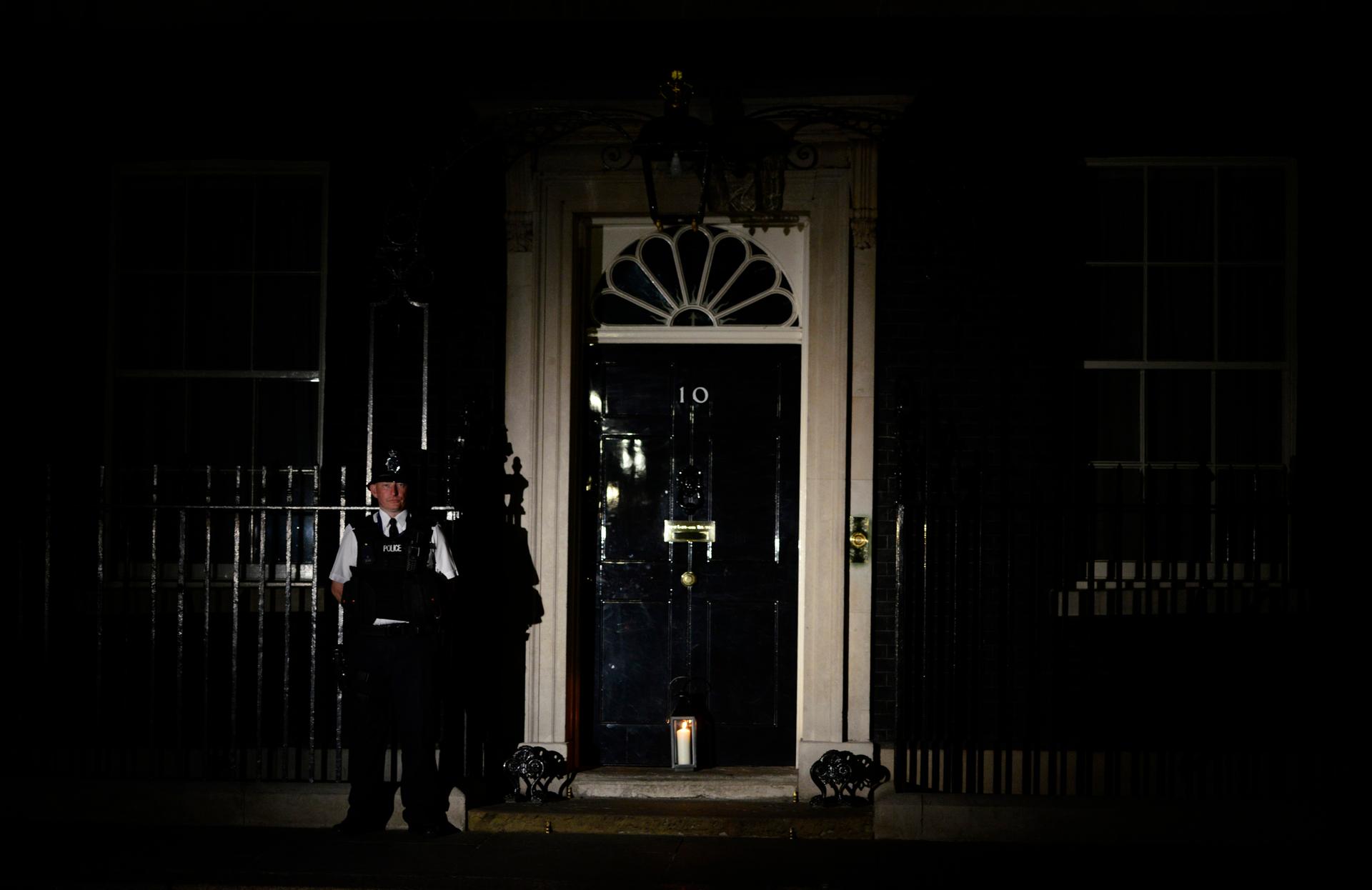 A policeman stands guard as a lantern is placed at the front door of Number 10 Downing Street during "Lights Out", as part of commemorations to mark the 100th anniversary of the outbreak of World War I on August 4, 2014.