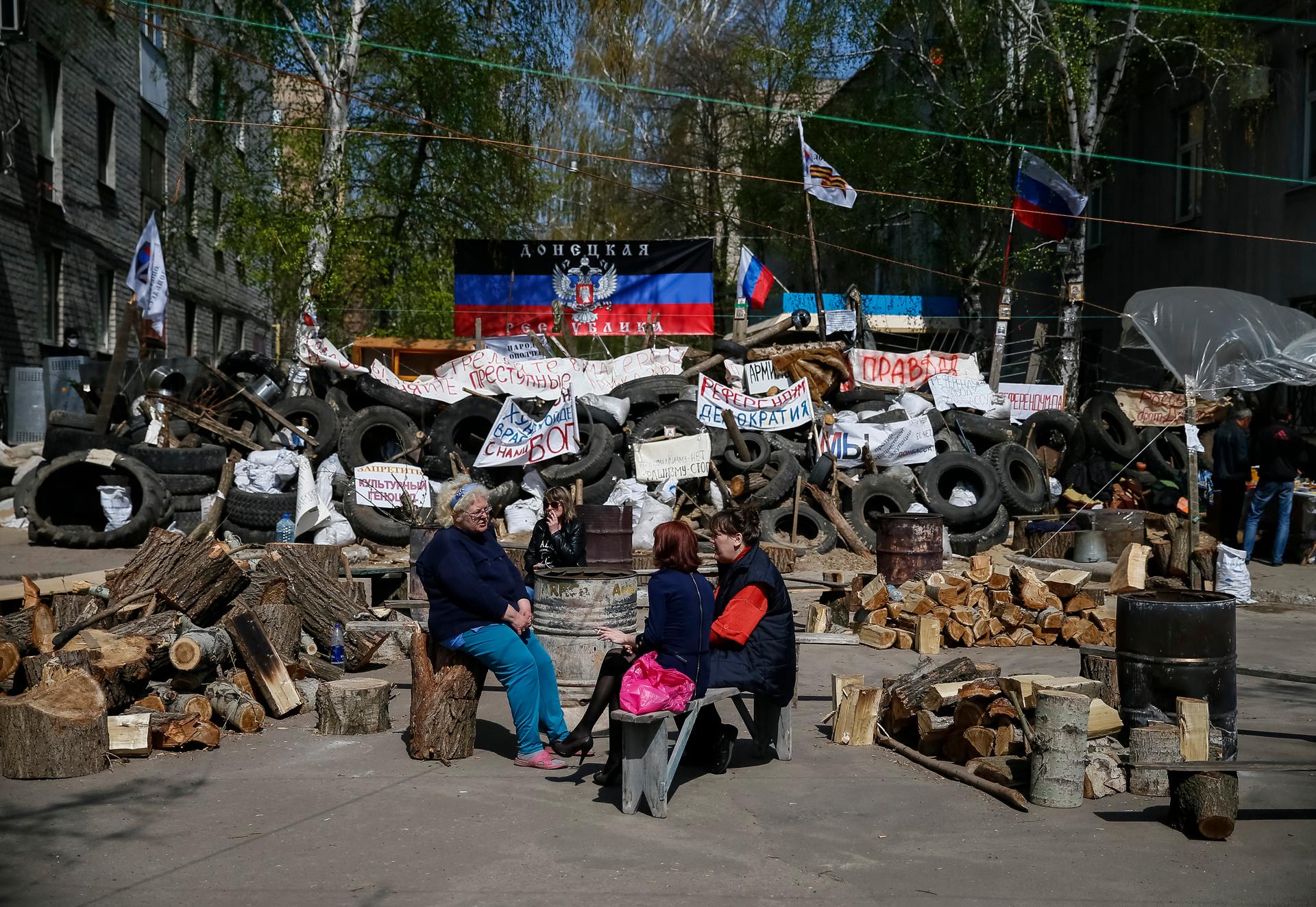 Pro-Russian protesters sit near barricades at the police headquarters in the eastern Ukrainian town of Slaviansk April 18, 2014. The self-declared leader of pro-Russian separatists in eastern Ukraine, Denis Pushilin, on Friday said that he did not conside