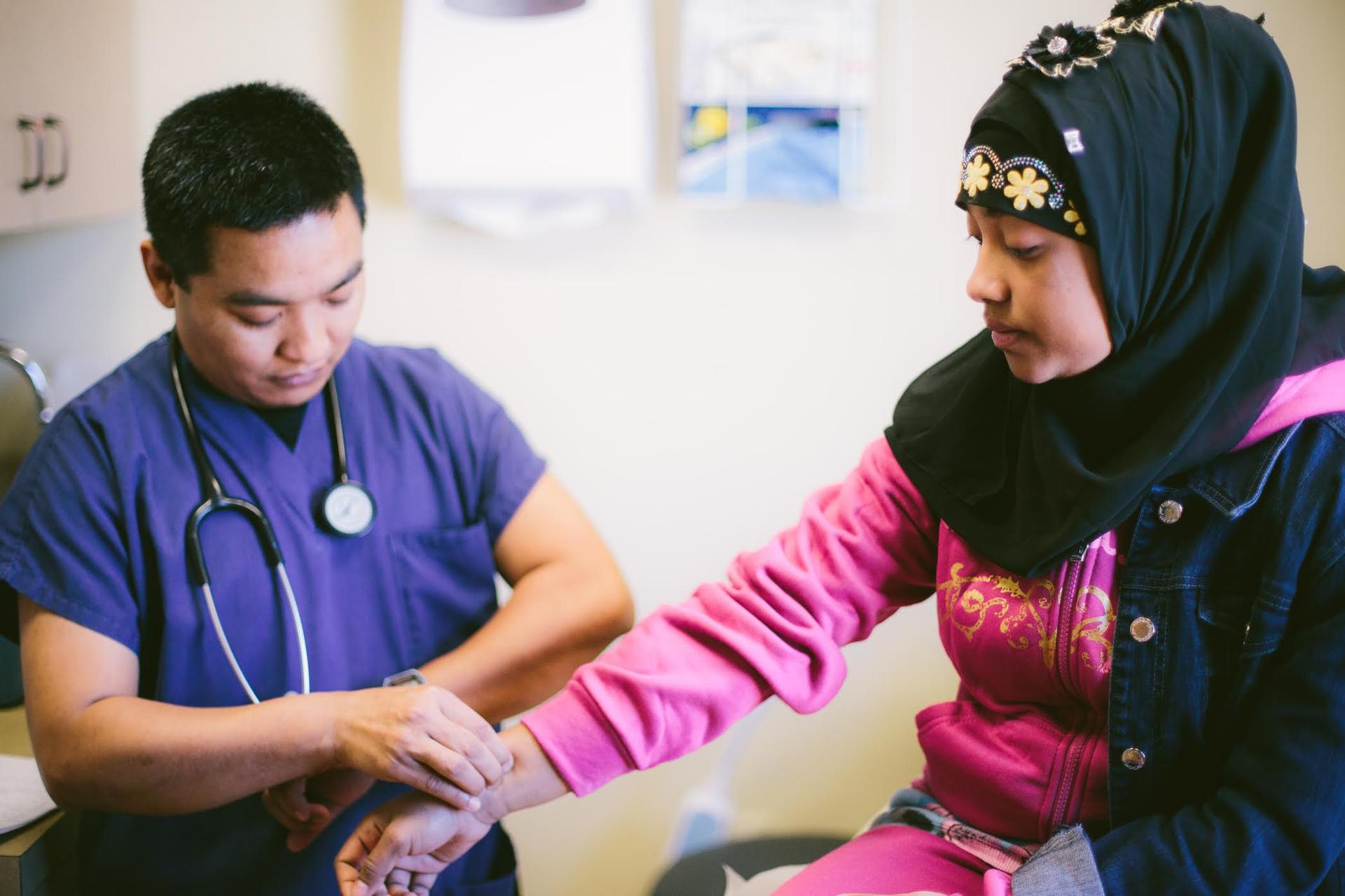 A woman gets her pulse checked at Jericho Road Community Health Center, a health center that focuses on culturally sensitive health care for refugees. 