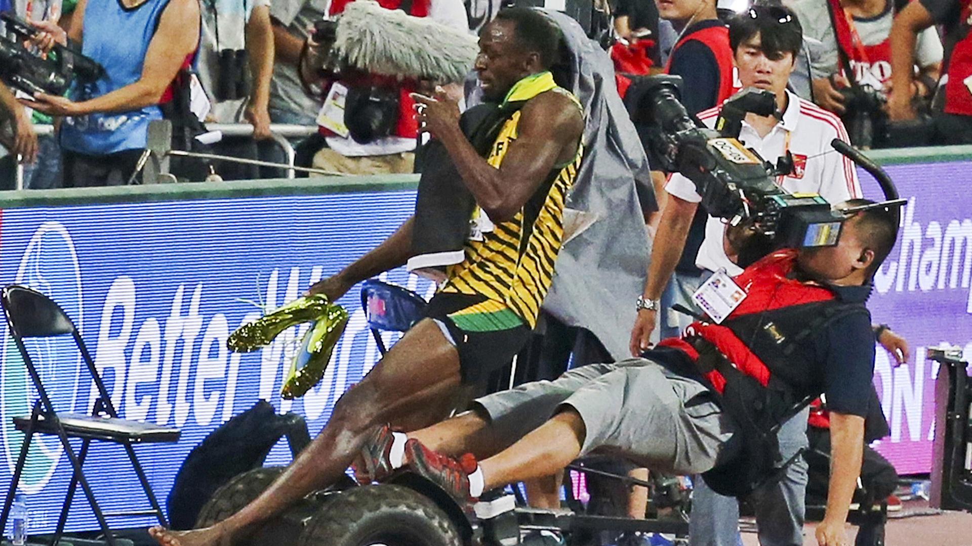 Usain Bolt is hit by a cameraman on a Segway as he celebrates after winning the men's 200 metres final at the 15th IAAF World Championships at the National Stadium in Beijing, China, August 27, 2015.