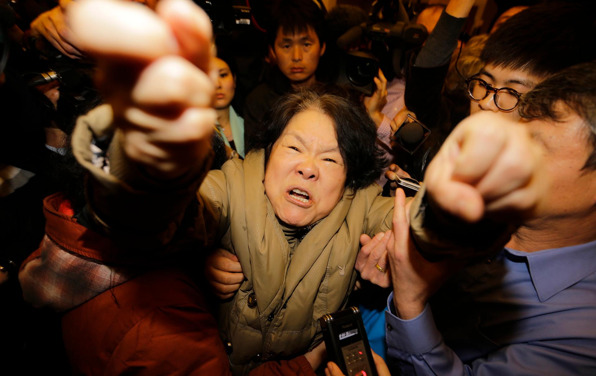 A family member of a passenger aboard Malaysia Airlines MH370 shouts at journalists at the Lido hotel in Beijing, March 24, 2014