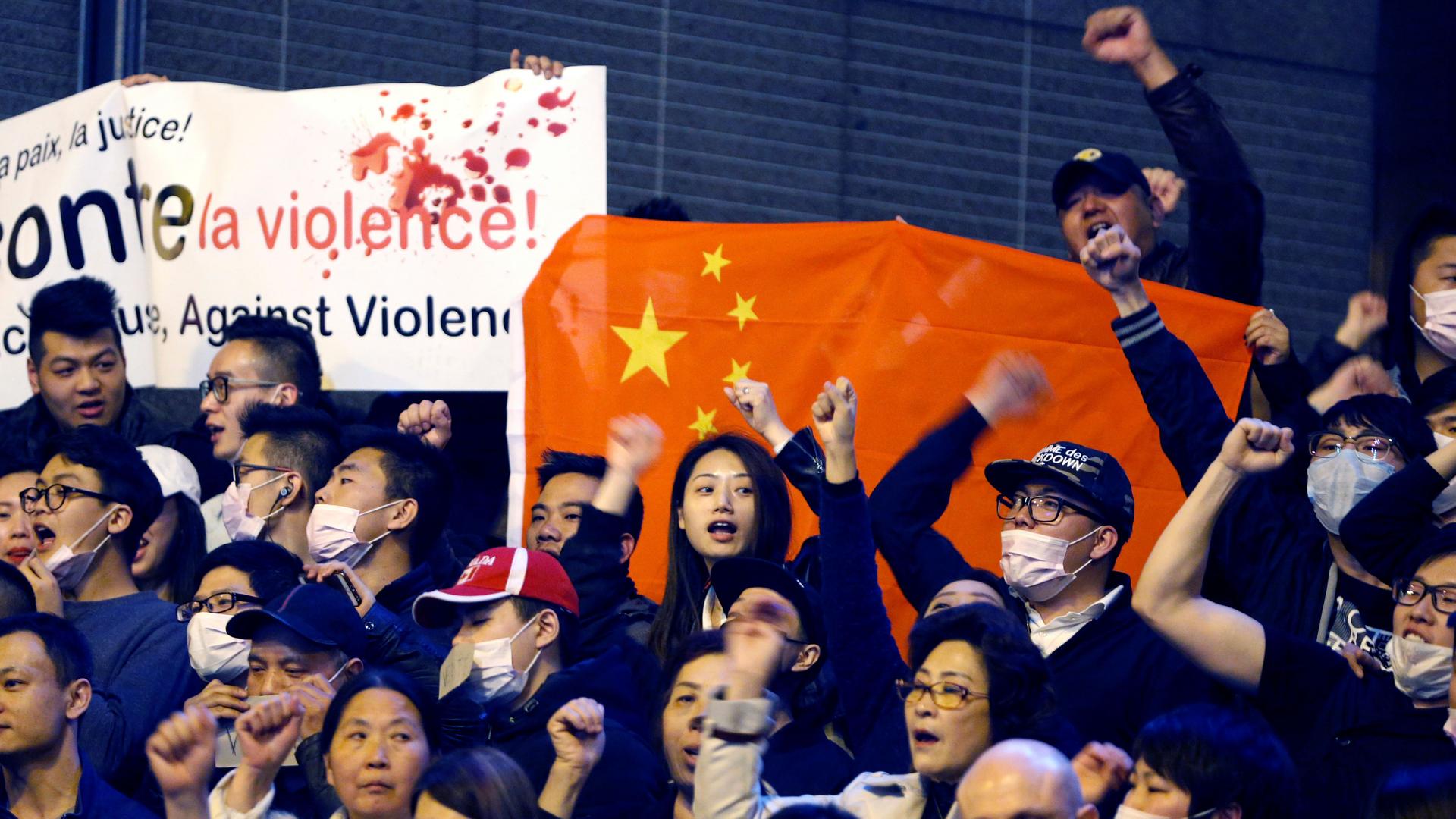 Members of the Chinese community shout slogans during a protest at Place de la Bastille in Paris, France, March 30, 2017.
