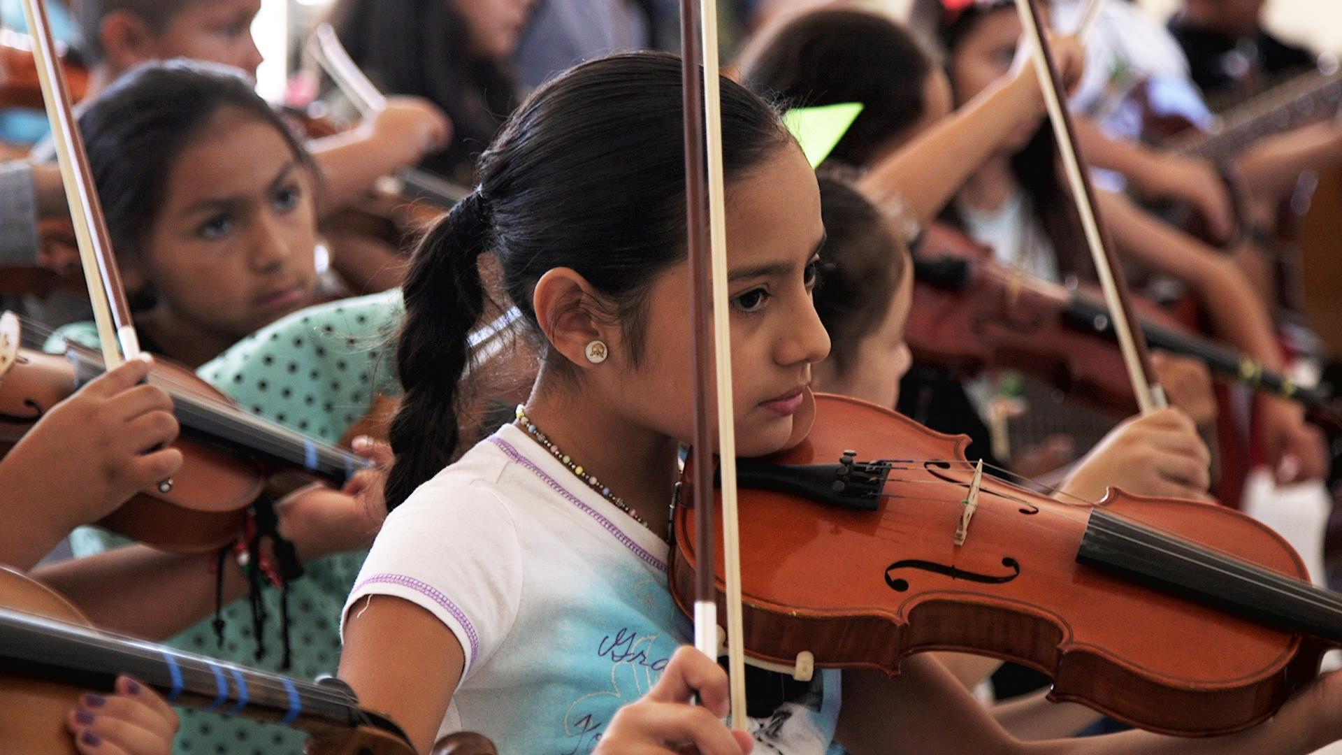 Yuritzi Guerrero practices violin with several other campers.