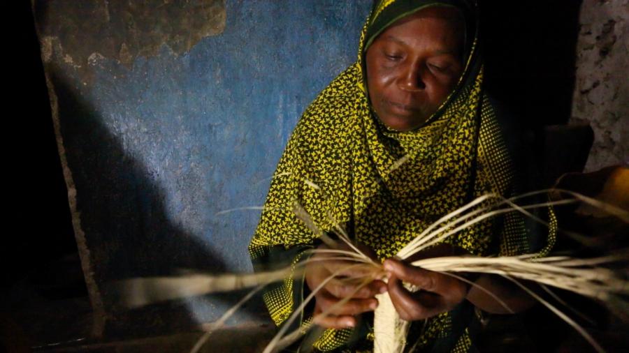 Kanoa Sharif Haji, a 45 year old mother of eight, weaves reed mats at night under a bright solar powered LED light at her home in Matemwe. This new work at night earns her family an extra fifteen dollars a month, a huge amount in these parts.