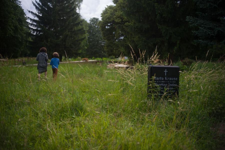 A mother and son from the neighborhood enter a community garden called “Die Gartnerei” that has sprung up in the retired section of the cemetery of the Jerusalem Church in the Berlin district of Neukolln. The garden grew up as a project of a non-profit ma