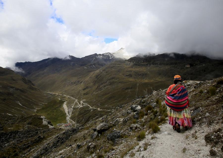 An Aymara indigenous woman walks on the Huayna Potosi mountain.