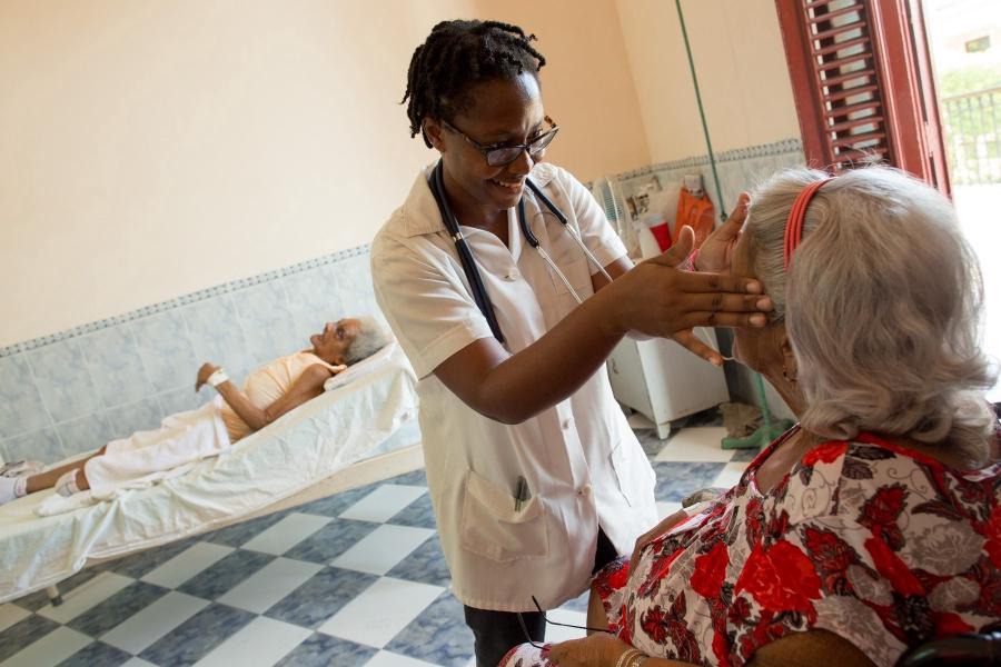 Samantha Marie Moore, a sixth-year ELAM student from Detroit, Michigan, examines Estrella Gomez Mesa, 76, during morning rounds at the Salvador Allende Hospital in Havana, Cuba, October 6, 2015. Behind is patient Ofelia Favier, 85. All US students at ELAM