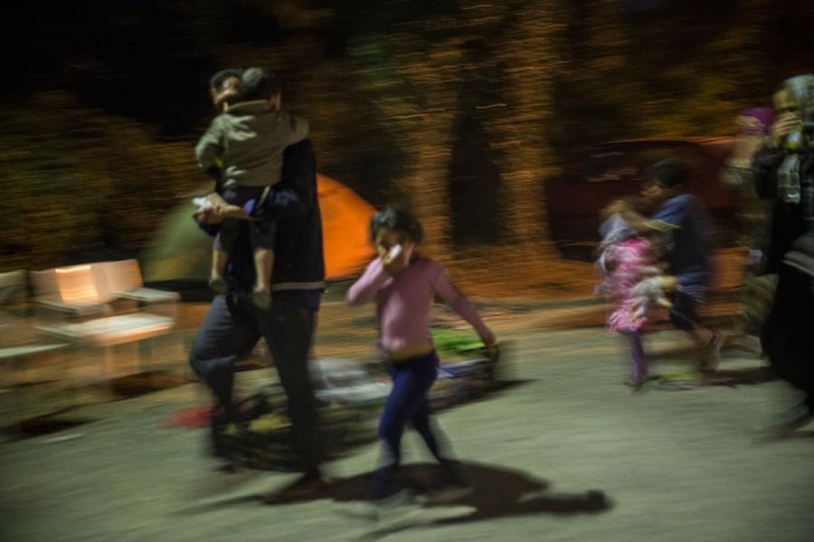 Families run after tear gas was fired by Greek police during the clashes.