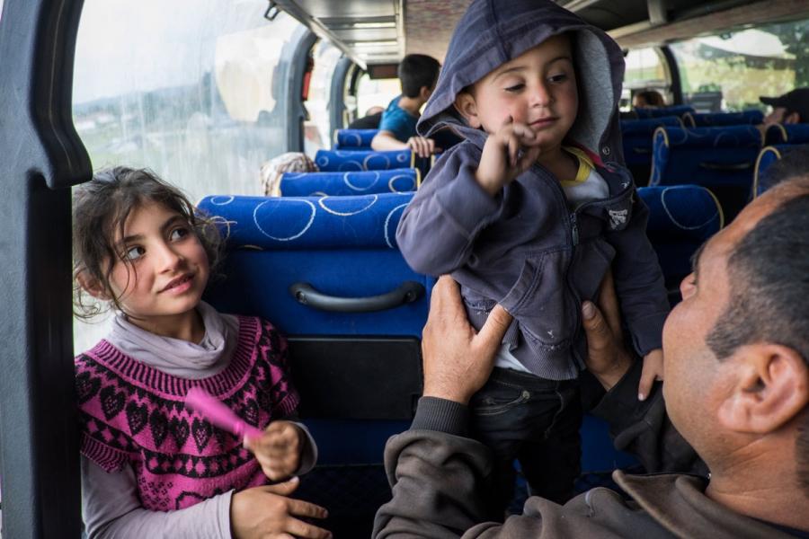 Syrian families aboard a bus bound for Oraikastro Camp after agreeing to leave Idomeni under police pressure. 