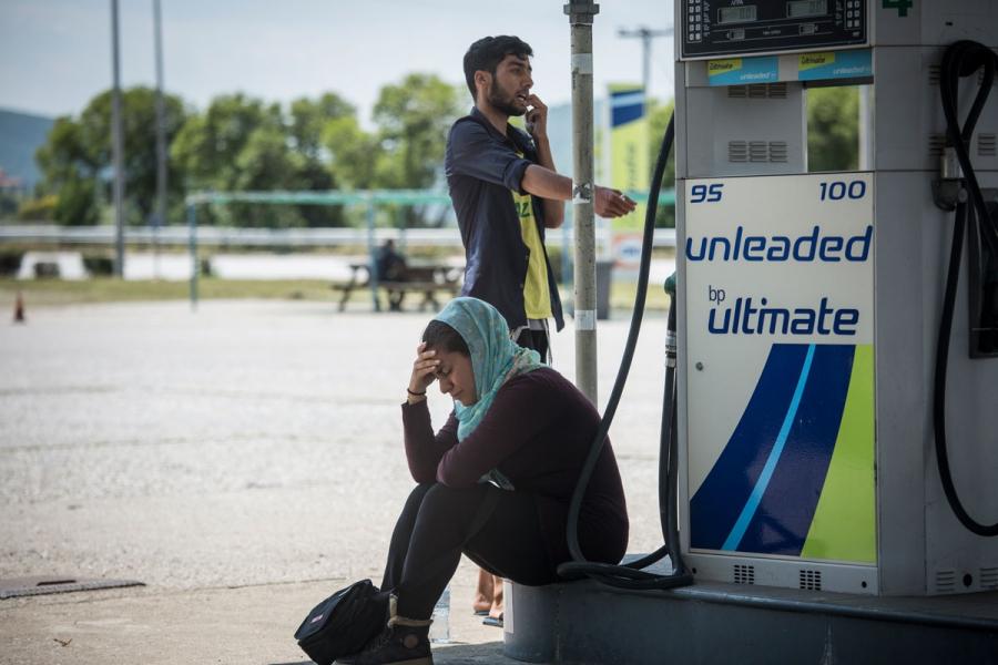 A woman cries at a gas station near Idomeni camp in Greece during Greek police operation to evacuate the camp.