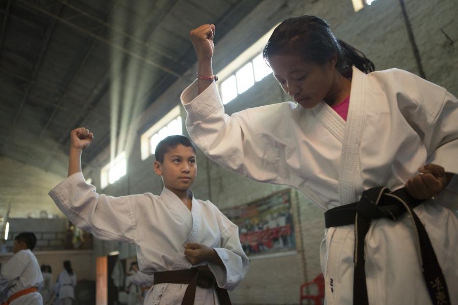 A young black belt leads Rai through a kata at the karate dojo where she trains daily in Kathmandu.