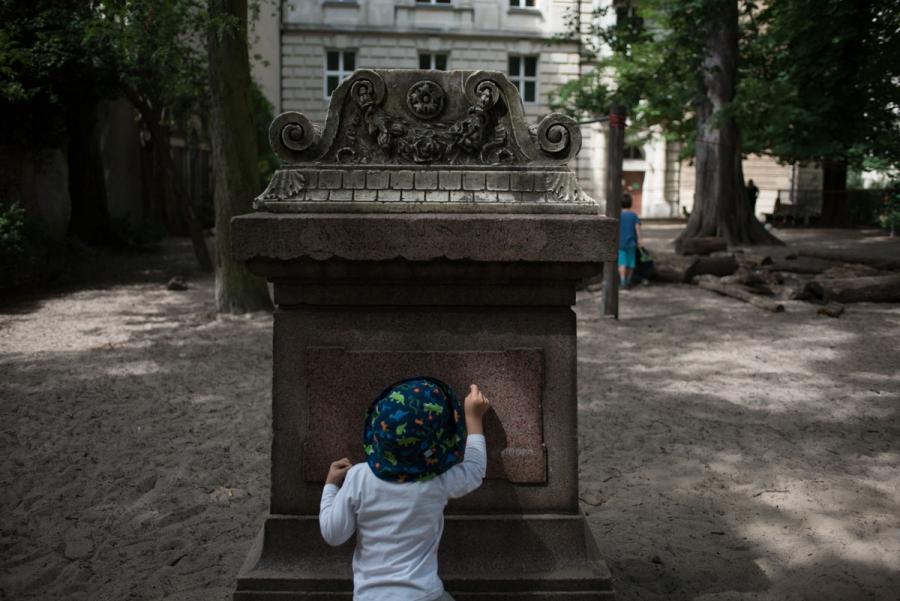 A pupil of the Sophienkirche day-care makes marks on a gravestone in the center’s playground.