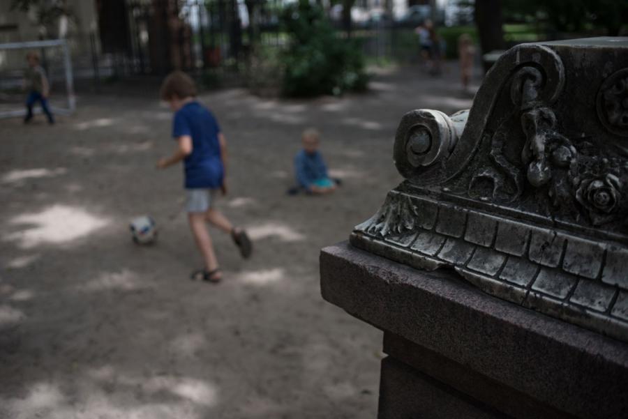 Pupils of the Sophienkirche day-care play soccer near a headstone in the center’s playground. On this afternoon, the headstone also serves as a boundary line for the game.