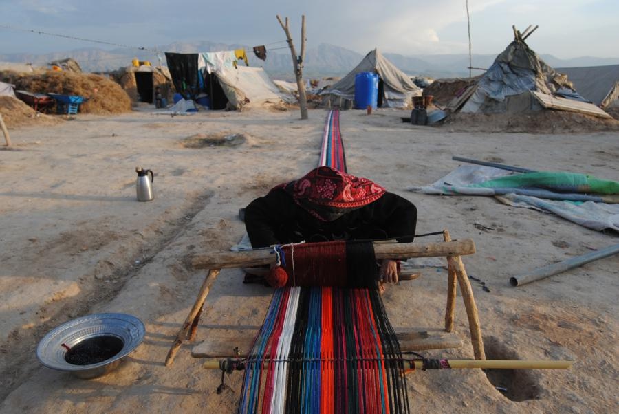 An Afghan woman weaves a carpet at a refugee camp in the outskirts of Mazar-i-Sharif, Afghanistan in April 2014. The women weave carpets and take care of the children at the camp which account for over half of the camp's population.