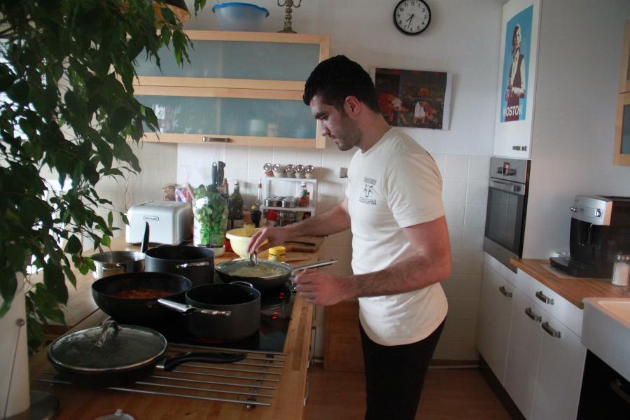 Kinan, a Syrian refugee, prepares a meal for the Jellinek family's Sabbath dinner in Berlin. He says he learned out to cook from youtube videos.