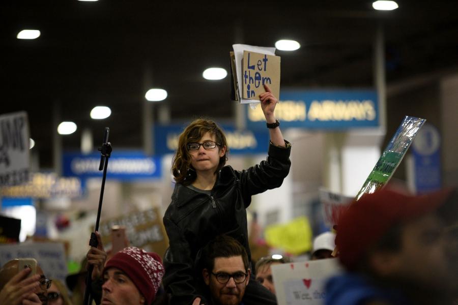 A young demonstrator holds a sign during anti-Donald Trump travel ban protests outside Philadelphia International Airport.