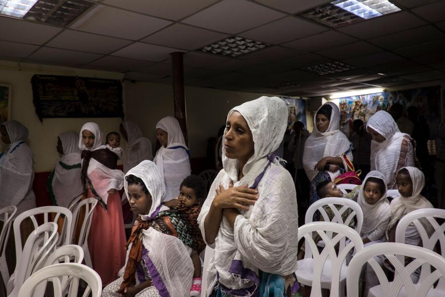 Brkitay Gebru prays at an Eritrean Church, one of many in an immigrant neighborhood of Tel Aviv. “Many women have no husbands They go to Africa, they go to Sudan, they go to Ethiopia … without women,” explained Father Ignatios Aragawi.