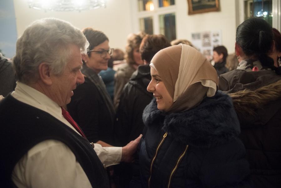 A member of Golzow's Protestant Church greets Rasha Haimoud following a holiday concert. Haimoud's family is one of three Syrian refugee families that moved to the village in the last year. The town invited the Muslim families to their annual Christmas co