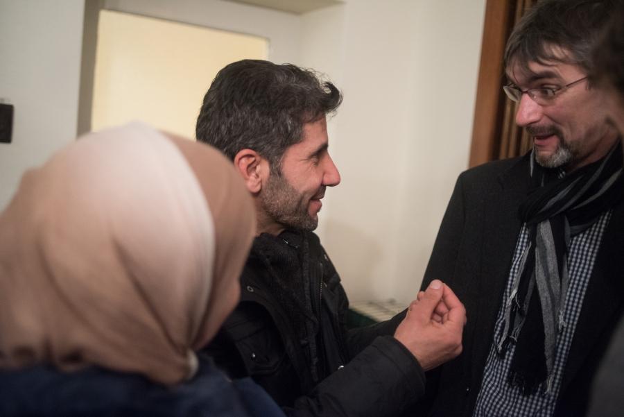 Ahmad Haimoud speaks with Golzow mayor Frank Schütz following a holiday concert and reception at the village's small Protestant Church. Schütz says he was happy to accept the families into their community as it allowed the city to fill then-empty apartmen