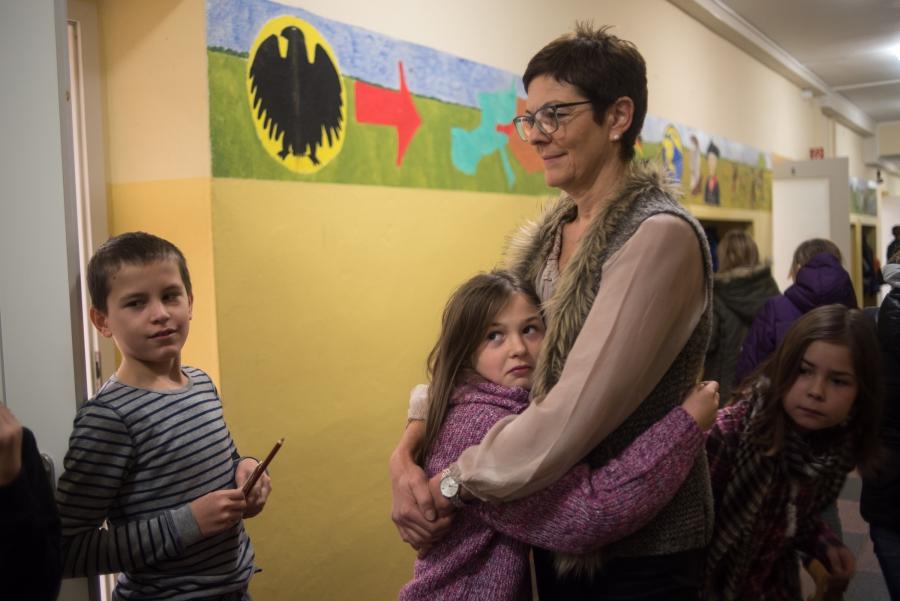 Gabriela Thomas, director of the elementary school in Golzow gives a student a hug between classes in the main hallway. Thomas says that the children of the refugee families are already fitting into her school very well.