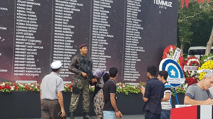 A woman kisses the hand of a plastic replica soldier, in front of a list of people killed during the coup attempt, in Istanbul's Taksim Square.